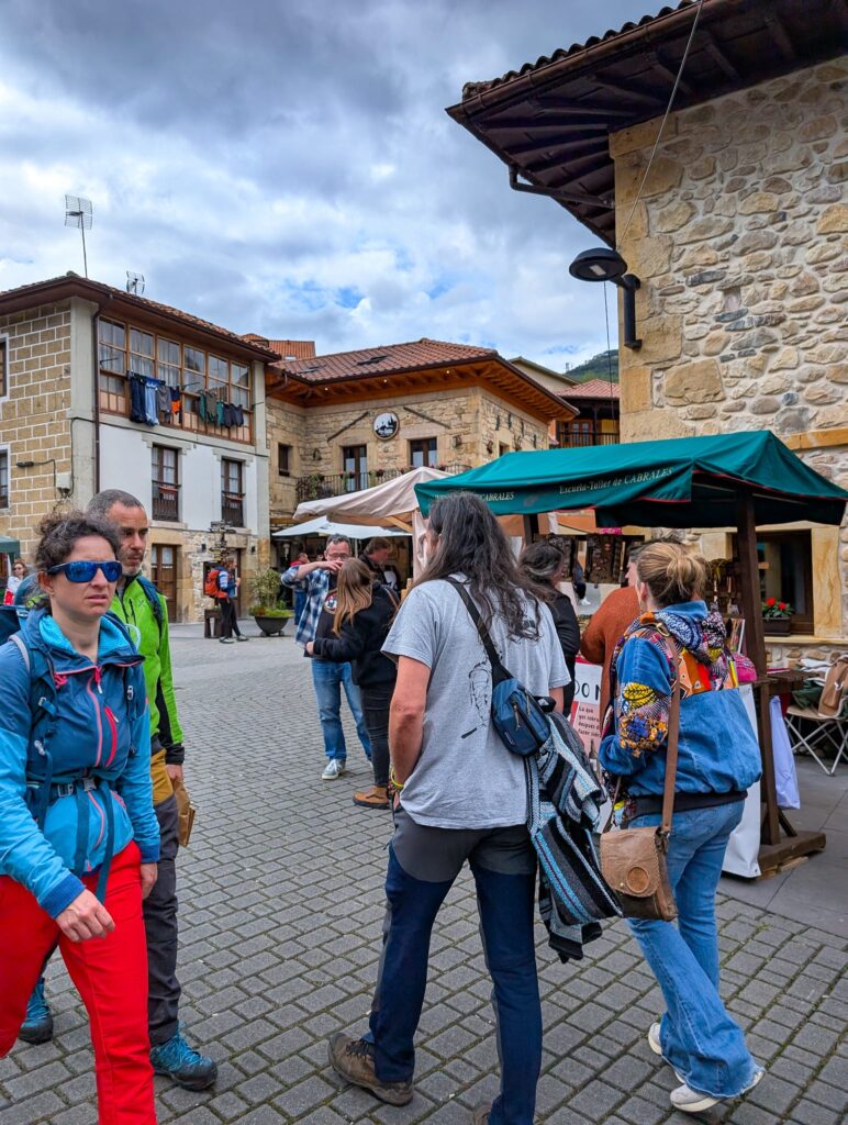 Visitantes del festival y montañeros por las calles de Arenas de Cabrales con los puestos de artesanía durante el Valgame Fest de 2025