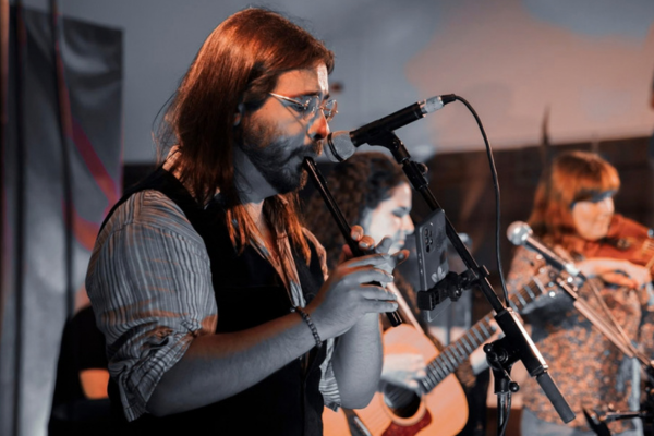 Héctor Aneiros tocand el tin whistle durante la actuación de Guieldu en el Festillingües. 