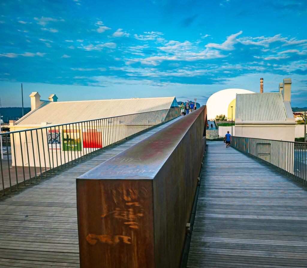 La passerelle traverse l’ancien bâtiment et abrite les ascenseurs, les sanitaires et un espace polyvalent culturel.

